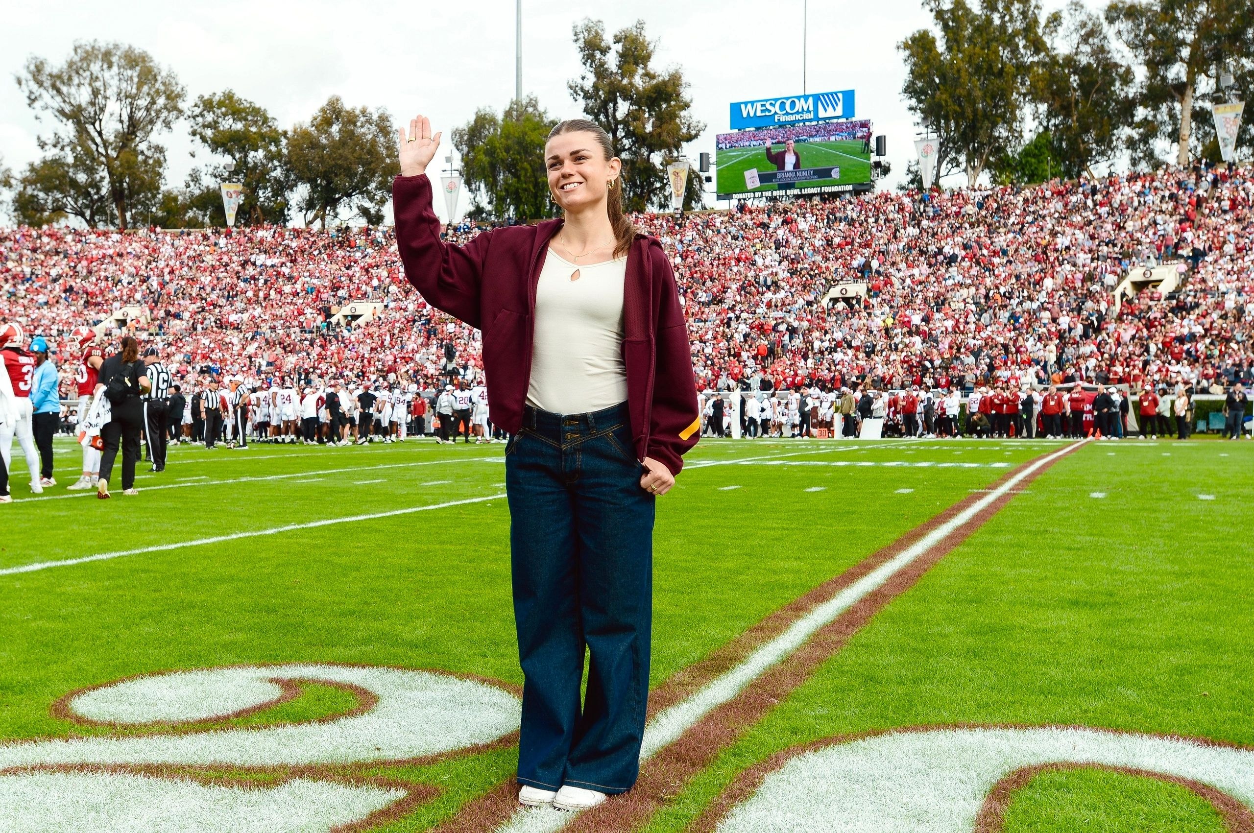 Bri Nunley on the football field at a packed stadium